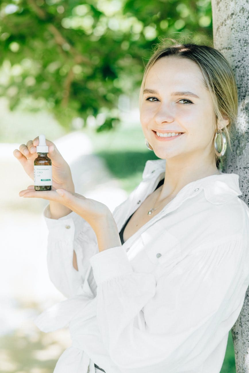 smiling woman in white dress shirt holding black smartphone